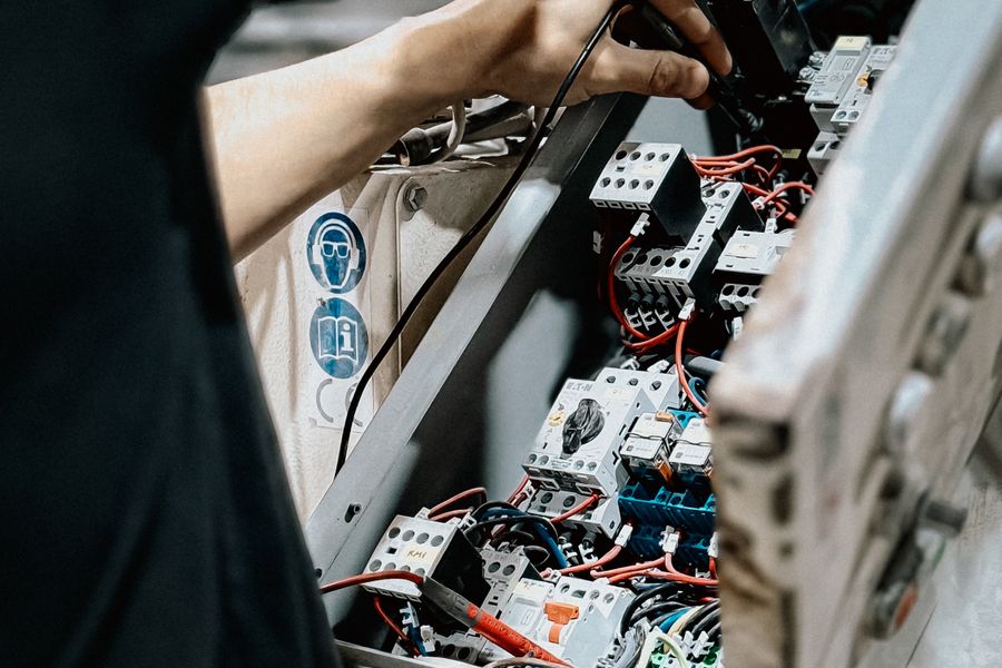 Technician working inside a commercial electrical control panel