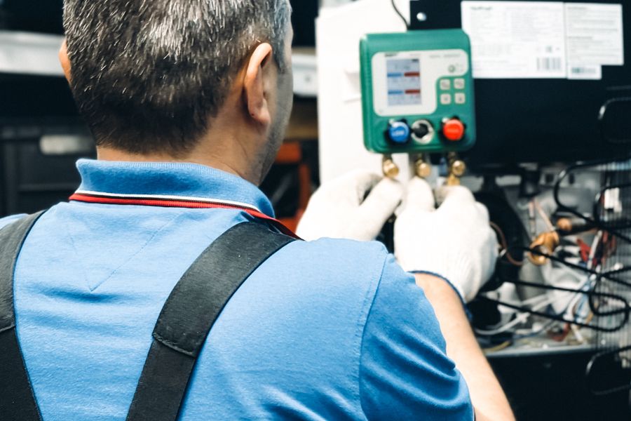 Uniformed technician testing a system with a digital manifold gauge